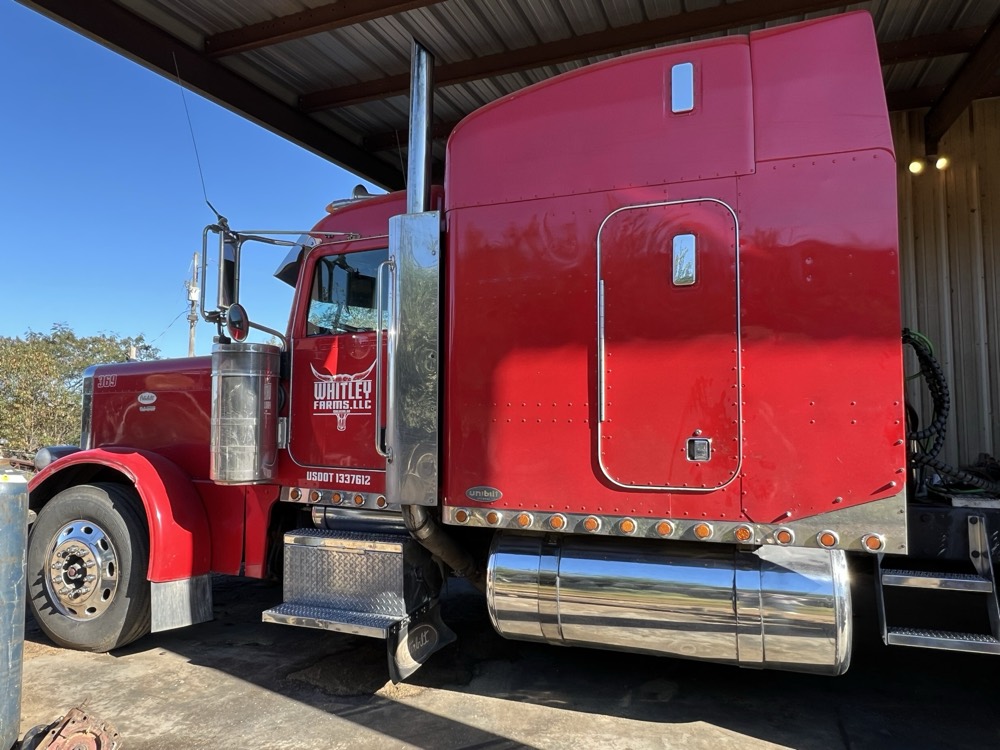 Whitley Farms LLC red Peterbilt semi truck parked under the barn